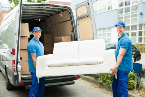 Furniture pick-up team collecting a sofa from a Harrow home